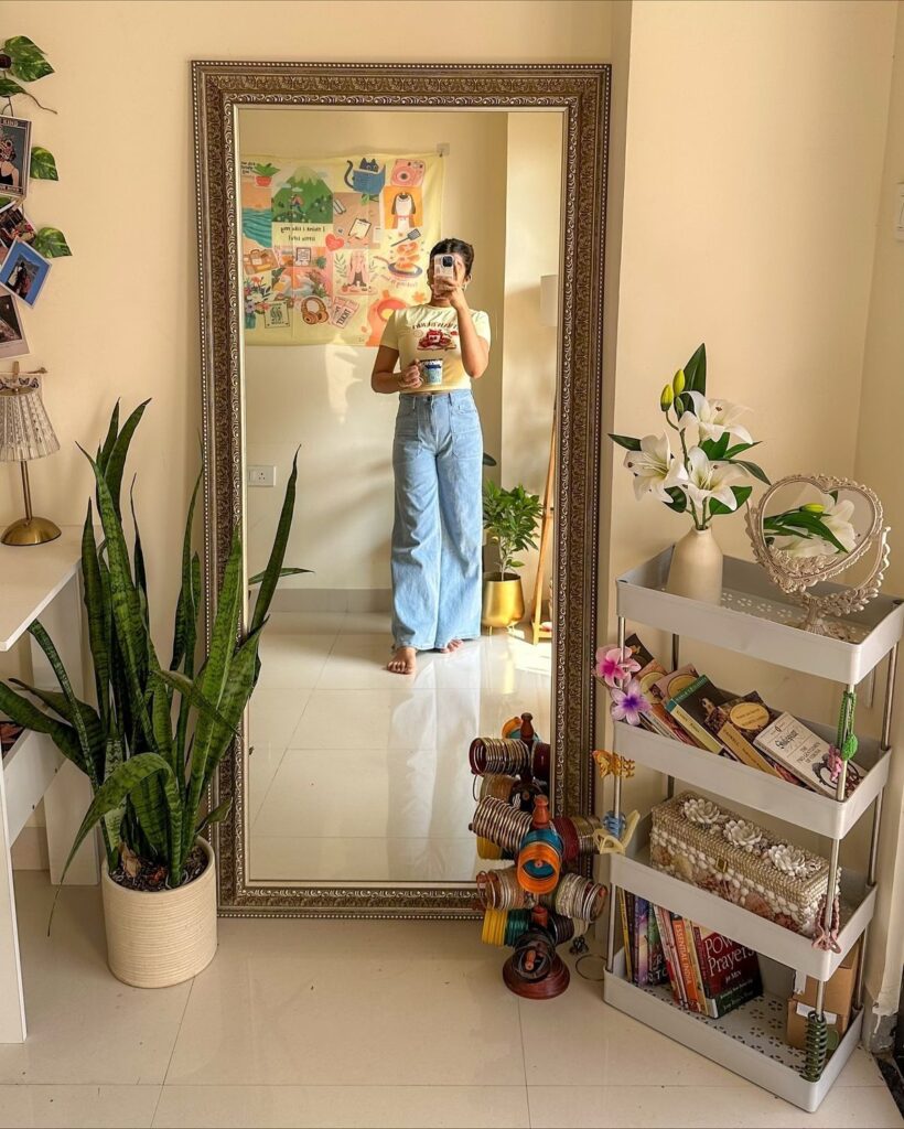 large standing mirror decor with plants and small storage shelf in apartment