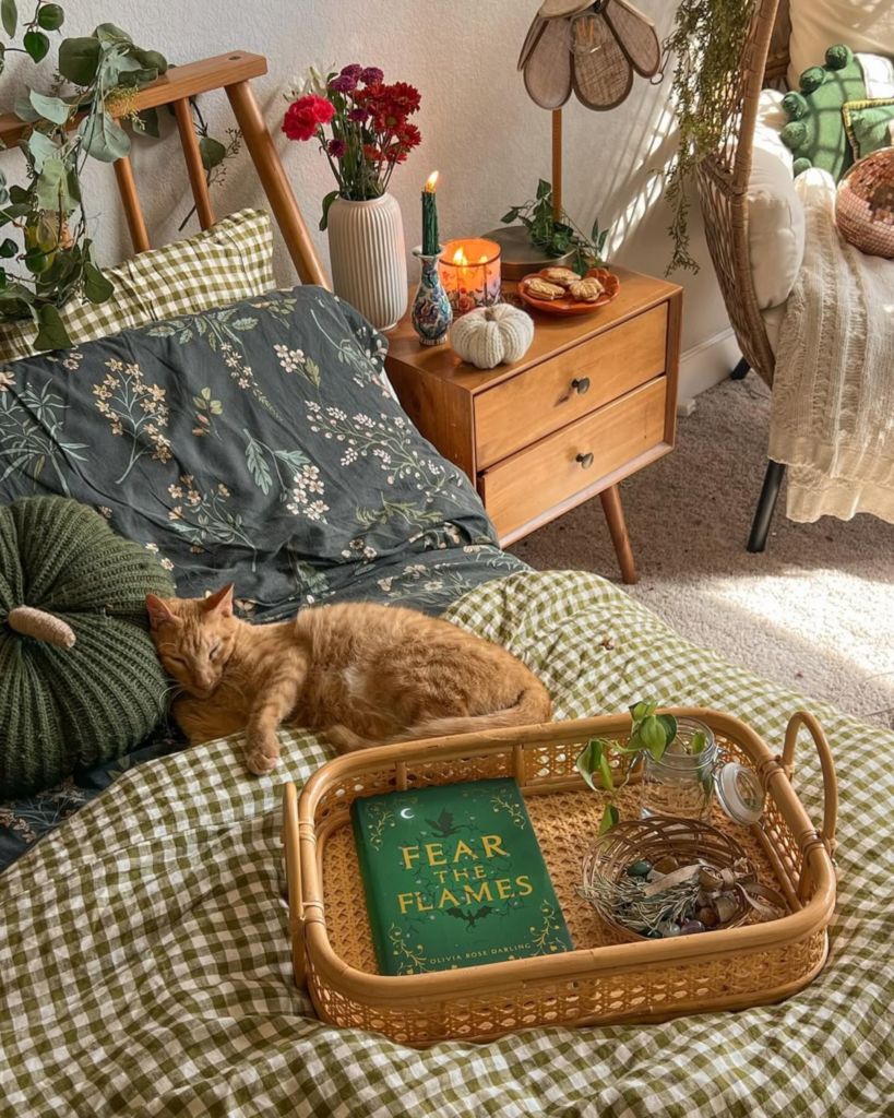 Simple bedside reading nook with books and pillows in a cozy apartment
