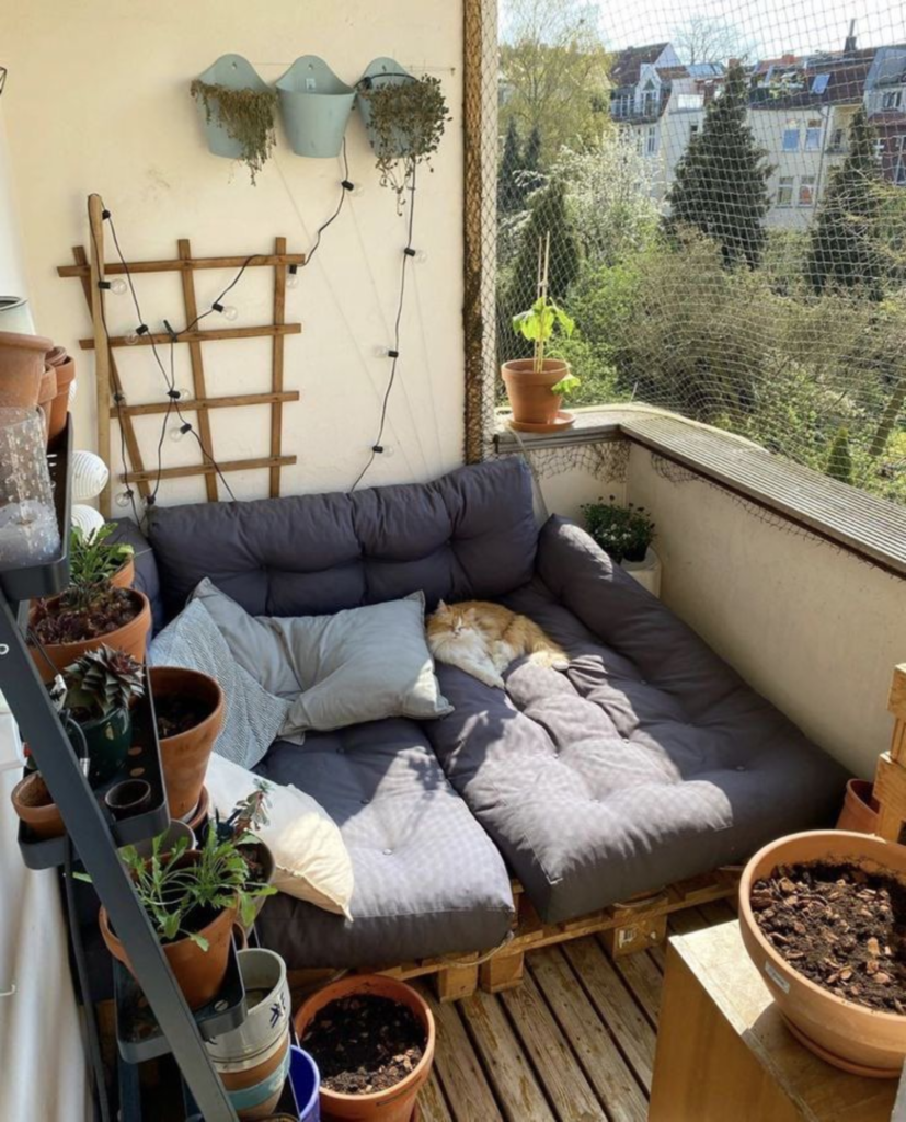 Small balcony reading nook with plants and compact seating