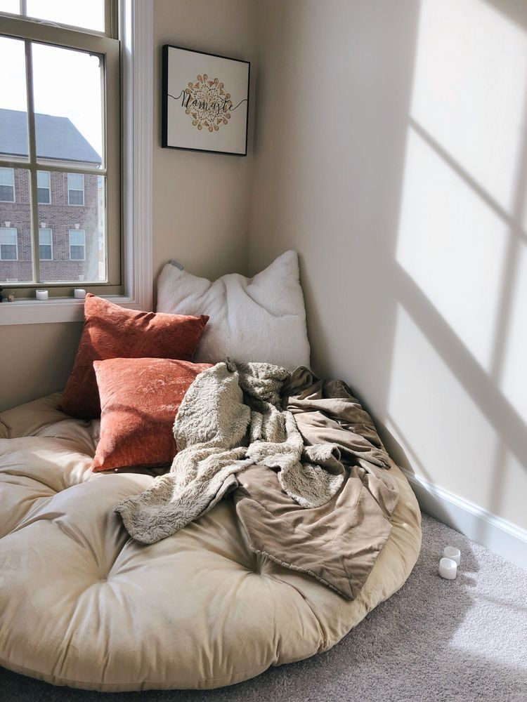 Soft cozy chair placed near window creating a reading nook in a small apartment