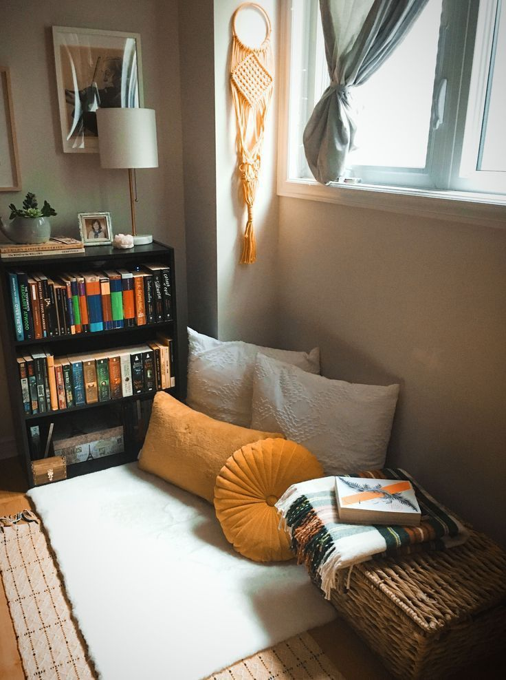 Small space reading nook with pillows and low bookshelf corner